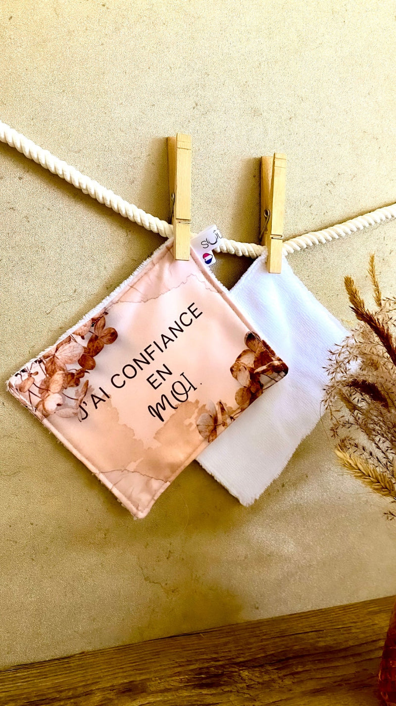 Lingette lavable modèle beige avec le message J'ai confiance en moi, suspendue avec une pince à linge.
