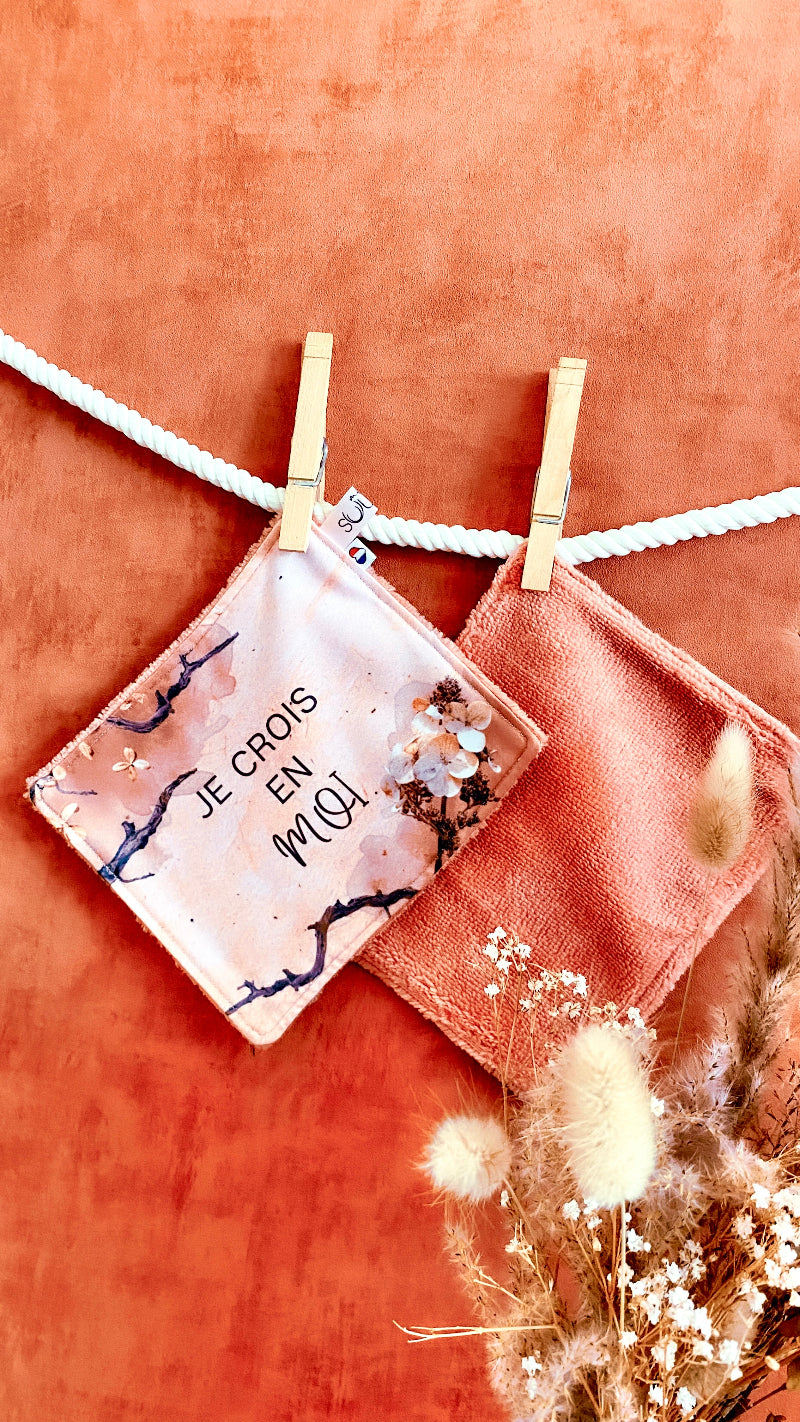 Lingette lavable modèle terracotta avec le message Je crois en moi, suspendue avec une pince à linge.