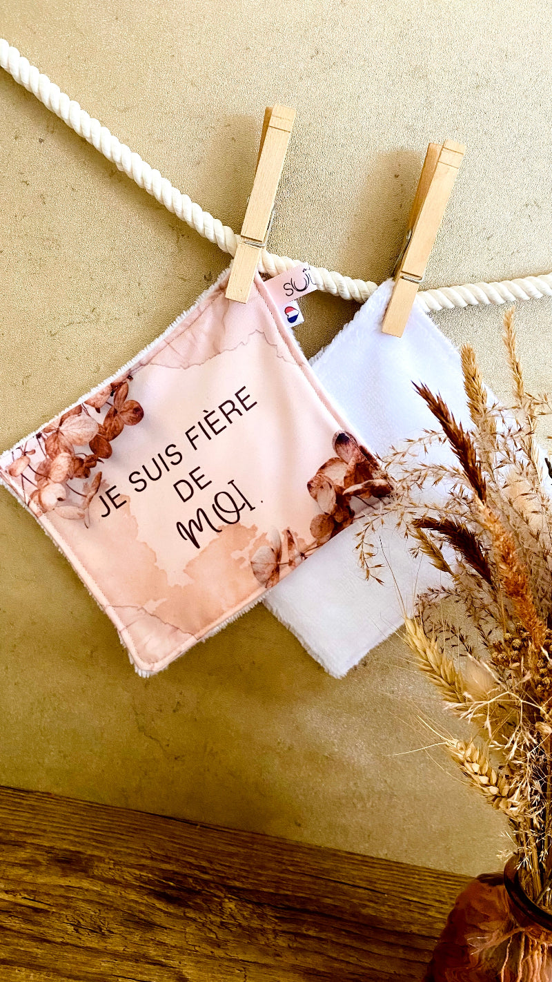 Lingette lavable modèle beige avec le message Je suis fière de moi, suspendue avec une pince à linge.